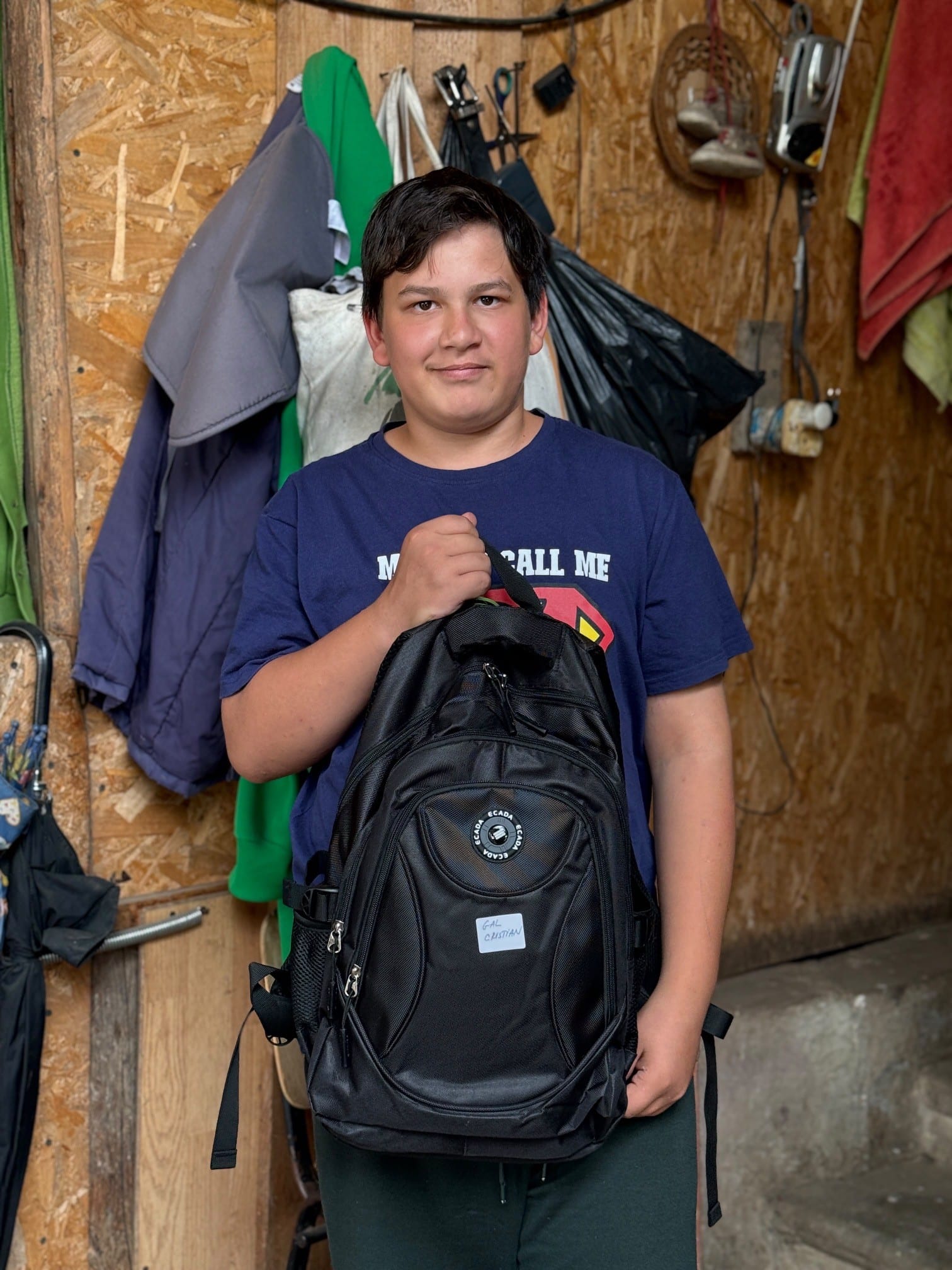 Child holding a new backpack.