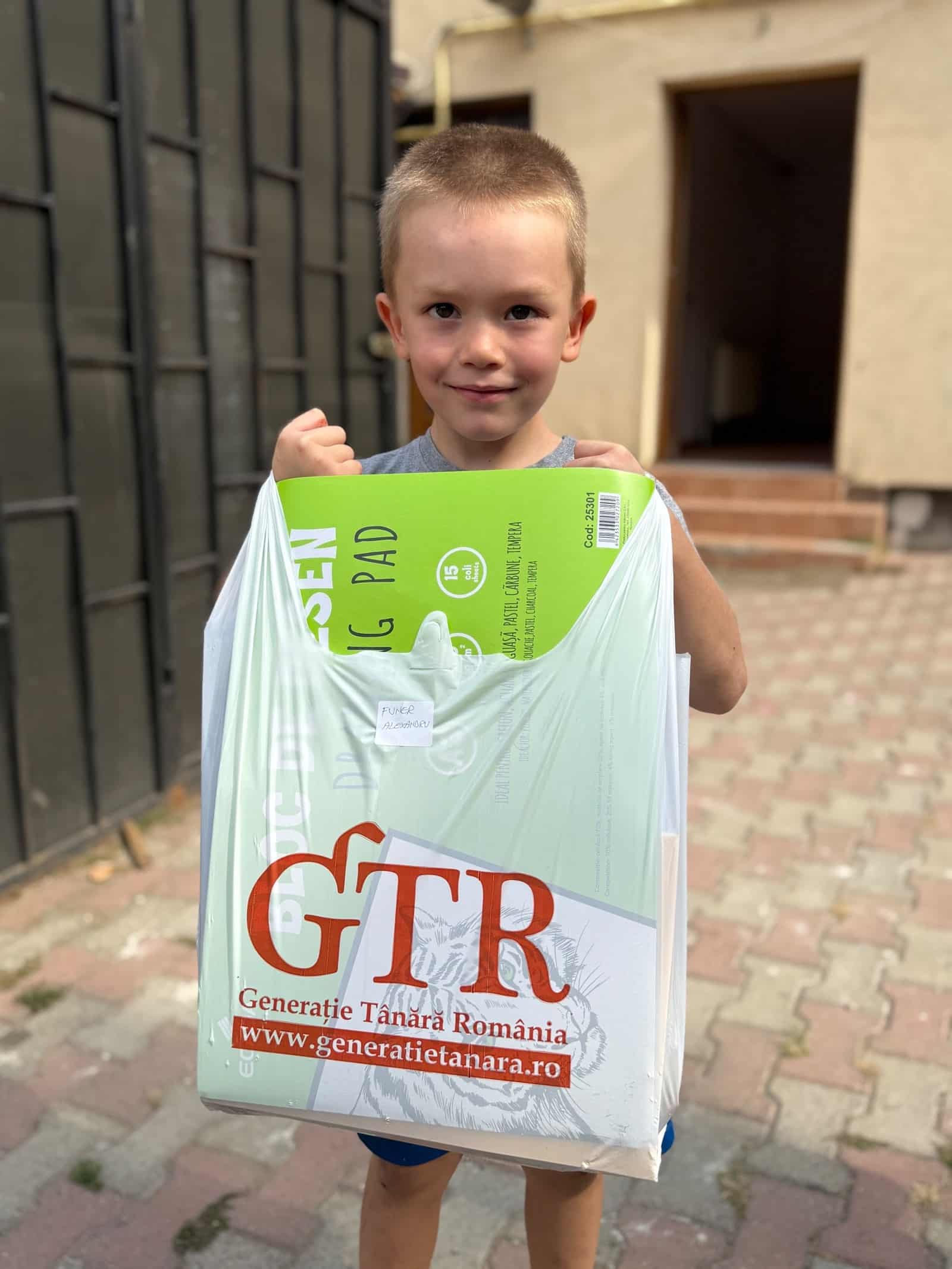 Child holding a bag with school supplies.